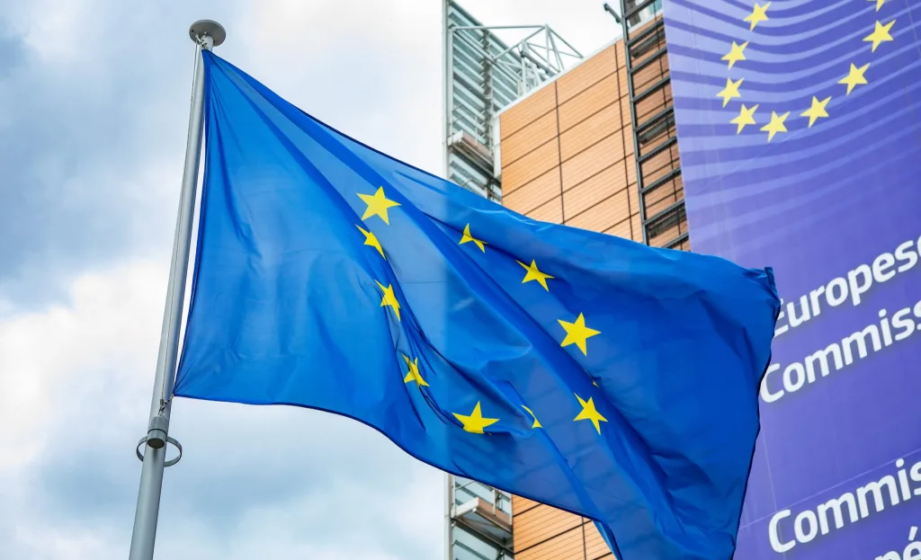 European Union flag in front of the Berlaymont building headquarters of European Commission 2048x1245 1